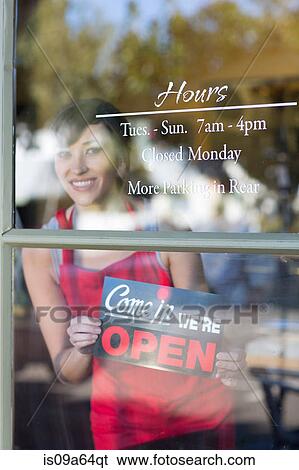 Waitress putting open sign in window View Large Photo Image Stock Photograph - Waitress putting open sign in window. Fotosearch