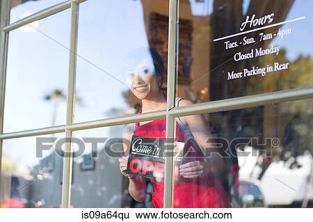Waitress putting open sign in window View Large Photo Image Stock Photograph - Waitress putting open sign in window. Fotosearch