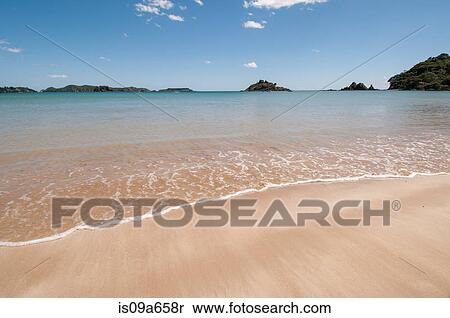Stock Photography - Waves washing up on tropical beach. Fotosearch