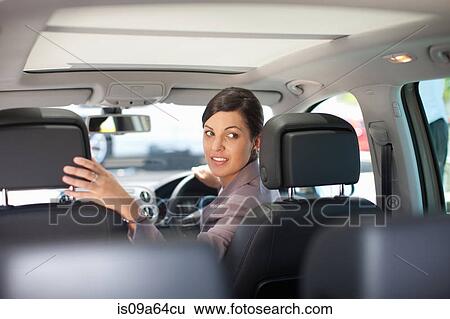 Woman backing up in car View Large Photo Image Stock Photograph - Woman backing up in car. Fotosearch