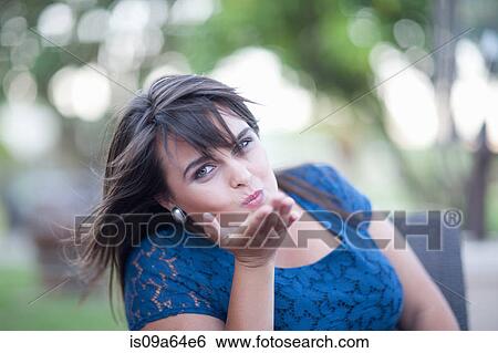 Stock Photograph - Woman blowing kiss outdoors. Fotosearch