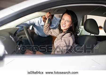 Stock Photo - Woman buying new car from salesman. Fotosearch