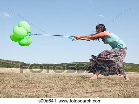 Woman carrying bunch of balloons View Large Photo Image Stock Image - Woman carrying bunch of balloons. Fotosearch