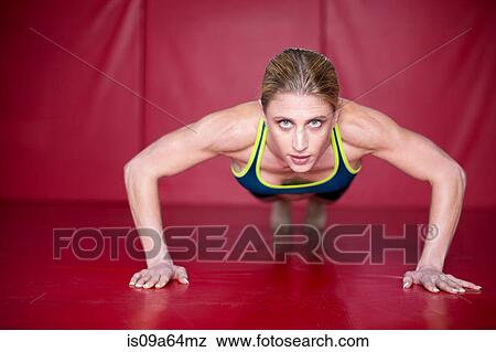 Stock Photo - Woman doing push ups in gym. Fotosearch