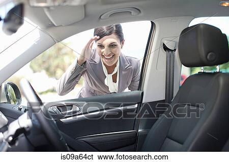 Stock Photograph - Woman examining new car. Fotosearch