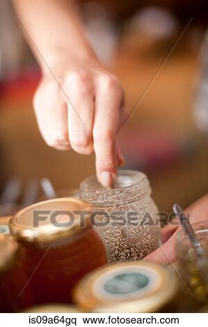 Stock Photography - Woman examining preserves in grocery. Fotosearch