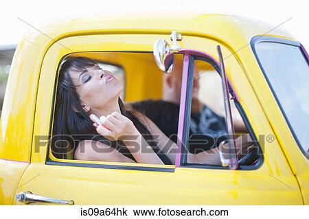 Woman fixing makeup in car mirror View Large Photo Image Stock Image - Woman fixing makeup in car mirror. Fotosearch