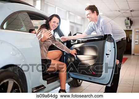 Woman getting in car at dealership View Large Photo Image Stock Image - Woman getting in car at dealership. Fotosearch