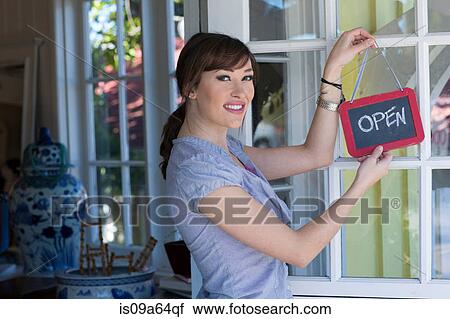 Woman hanging open sign on door View Large Photo Image Stock Image - Woman hanging open sign on door. Fotosearch