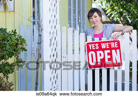 Woman hanging open sign on fence View Large Photo Image Stock Image - Woman hanging open sign on fence. Fotosearch