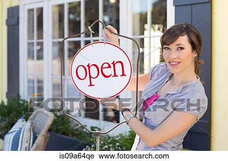 Woman hanging open sign on frame View Large Photo Image Stock Image - Woman hanging open sign on frame. Fotosearch