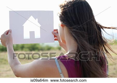 Picture - Woman holding card with house shape. Fotosearch