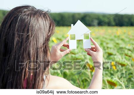 Woman holding card with house shape View Large Photo Image Stock Image - Woman holding card with house shape. Fotosearch