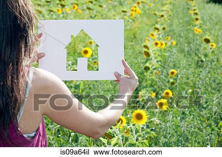 Stock Image - Woman holding card with house shape. Fotosearch