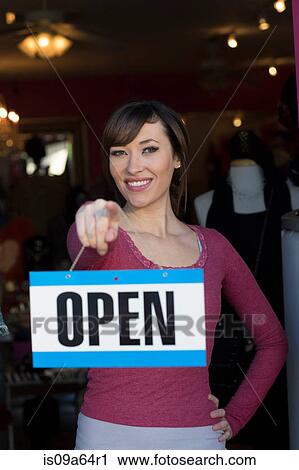 Woman holding open sign in store View Large Photo Image Stock Image - Woman holding open sign in store. Fotosearch