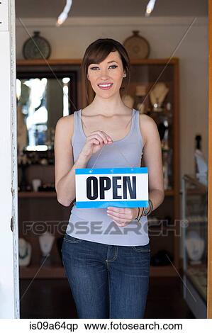 Woman holding open sign in store View Large Photo Image Stock Photography - Woman holding open sign in store. Fotosearch