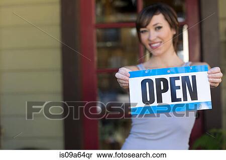 Stock Photography - Woman holding open sign outdoors. Fotosearch