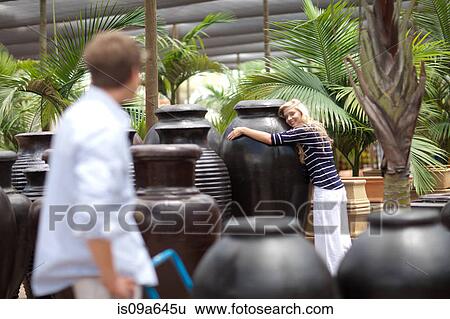 Stock Photograph - Woman hugging large planter. Fotosearch