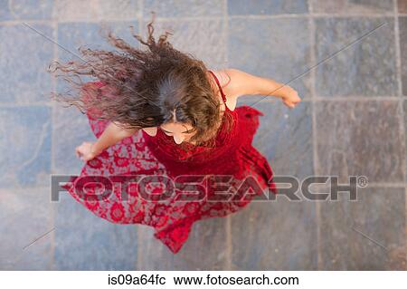 Stock Image - Woman in gown spinning outdoors. Fotosearch