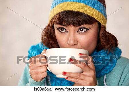 Stock Image - Woman in scarf drinking cup of coffee. Fotosearch