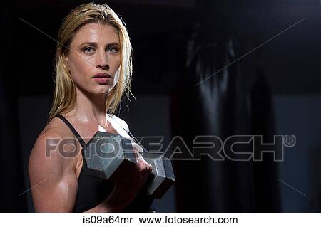 Stock Photography - Woman lifting weights in gym. Fotosearch