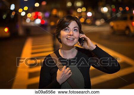 Stock Image - Woman on cell phone on city street. Fotosearch