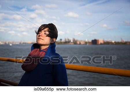 Stock Photography - Woman on ferry in urban harbor. Fotosearch