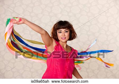 Stock Image - Woman playing with ribbon streamers. Fotosearch
