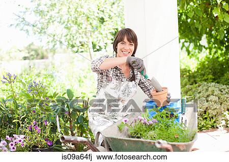 Woman potting plants outdoors View Large Photo Image Stock Image - Woman potting plants outdoors. Fotosearch