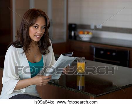 Woman reading newspaper at breakfast View Large Photo Image Stock Image - Woman reading newspaper at breakfast. Fotosearch