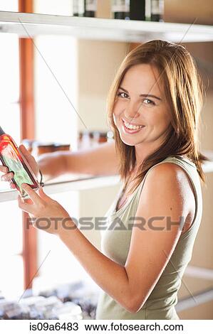 Woman reading vinegar bottle in grocery View Large Photo Image Stock Image - Woman reading vinegar bottle in grocery. Fotosearch