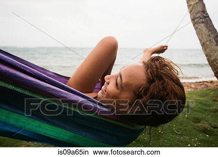 Woman relaxing in hammock on beach View Large Photo Image Picture - Woman relaxing in hammock on beach. Fotosearch