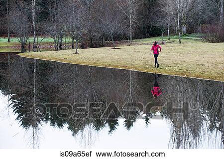 Woman running by still rural lake View Large Photo Image Stock Image - Woman running by still rural lake. Fotosearch