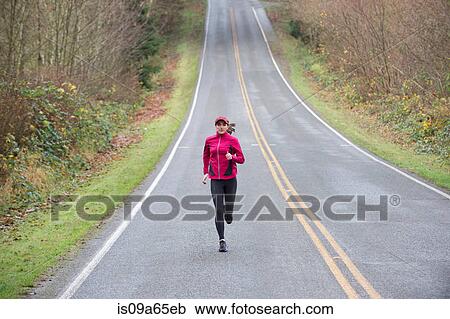 Woman running on rural road View Large Photo Image Stock Image - Woman running on rural road. Fotosearch