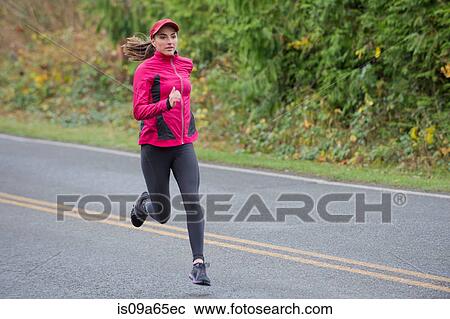 Woman running on rural road View Large Photo Image Stock Image - Woman running on rural road. Fotosearch