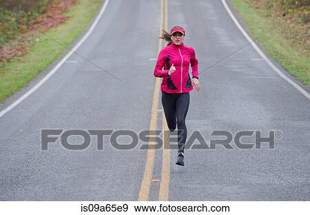 Stock Photo - Woman running on rural road. Fotosearch
