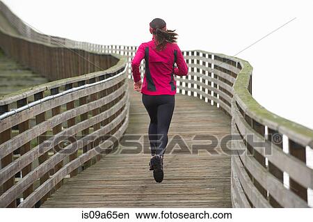 Woman running on wooden dock View Large Photo Image Picture - Woman running on wooden dock. Fotosearch