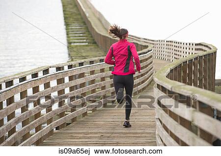 Woman running on wooden dock View Large Photo Image Stock Image - Woman running on wooden dock. Fotosearch
