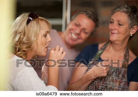 Stock Photo - Woman tasting olives in grocery store. Fotosearch