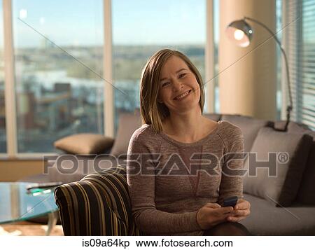 Woman using cell phone on sofa View Large Photo Image Stock Photography - Woman using cell phone on sofa. Fotosearch