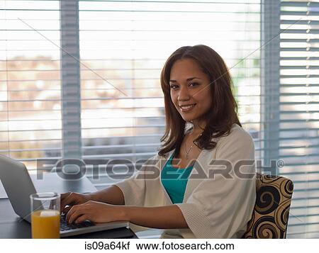 Woman using laptop at desk View Large Photo Image Stock Image - Woman using laptop at desk. Fotosearch