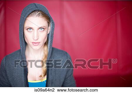 Stock Image - Woman wearing hoodie in gym. Fotosearch