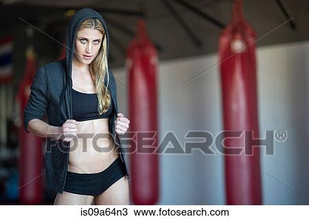 Stock Image - Woman wearing hoodie in gym. Fotosearch