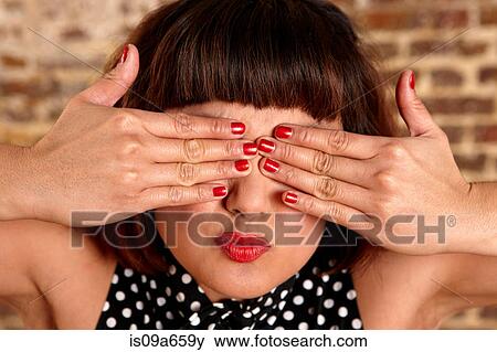 Woman with kissy face covering her eyes View Large Photo Image Stock Photo - Woman with kissy face covering her eyes. Fotosearch