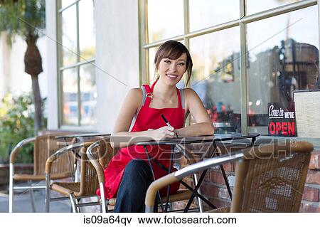 Stock Photo - Woman writing at cafe table. Fotosearch
