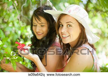 Stock Photography - Women admiring flowers in park. Fotosearch