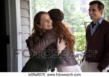 Women hugging at front door View Large Photo Image Stock Photography - Women hugging at front door. Fotosearch