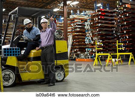 Worker and businessman in metal plant View Large Photo Image Stock Photograph - Worker and businessman in metal plant. Fotosearch