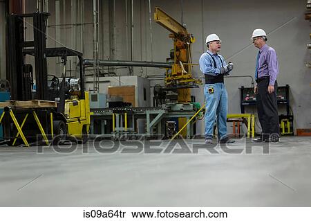 Stock Photography - Worker and businessman in metal plant. Fotosearch