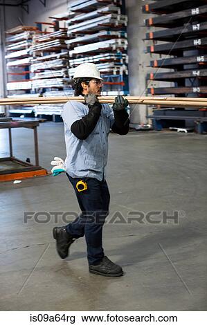 Worker carrying pipes in metal plant View Large Photo Image Stock Image - Worker carrying pipes in metal plant. Fotosearch